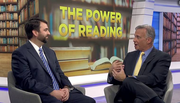 2 people, people sitting, text that says 'THE POWER OF READING'